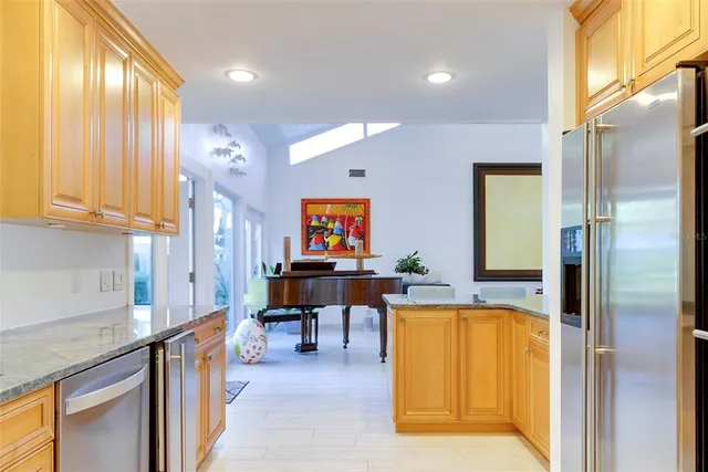 a kitchen with stainless steel appliances granite countertop a table chairs in it and wooden floors