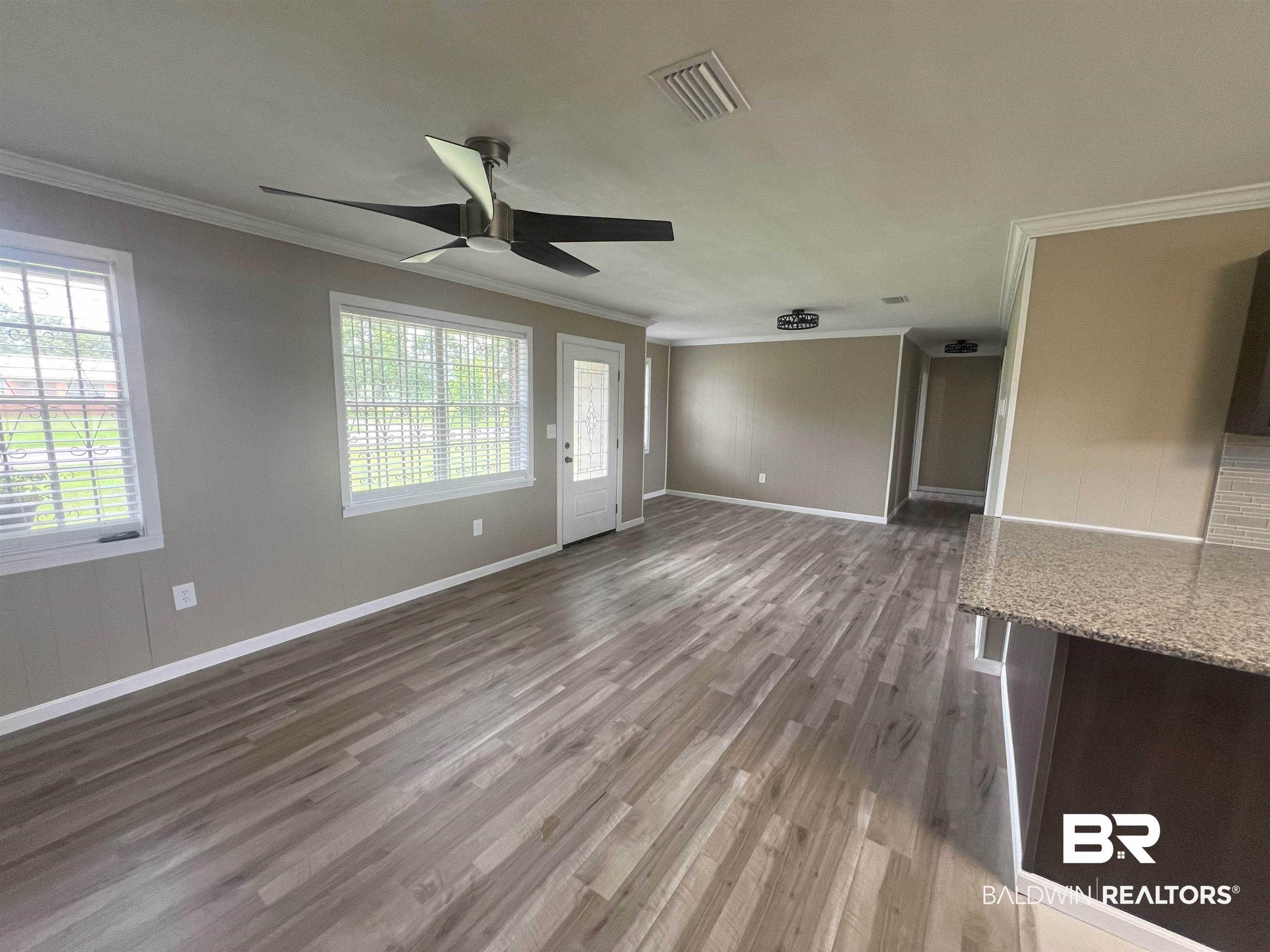 508 Freemanville Drive Atmore, AL 36502 - Photo 8 of 27 Unfurnished living room with crown molding, ceiling fan, and hardwood / wood-style floors