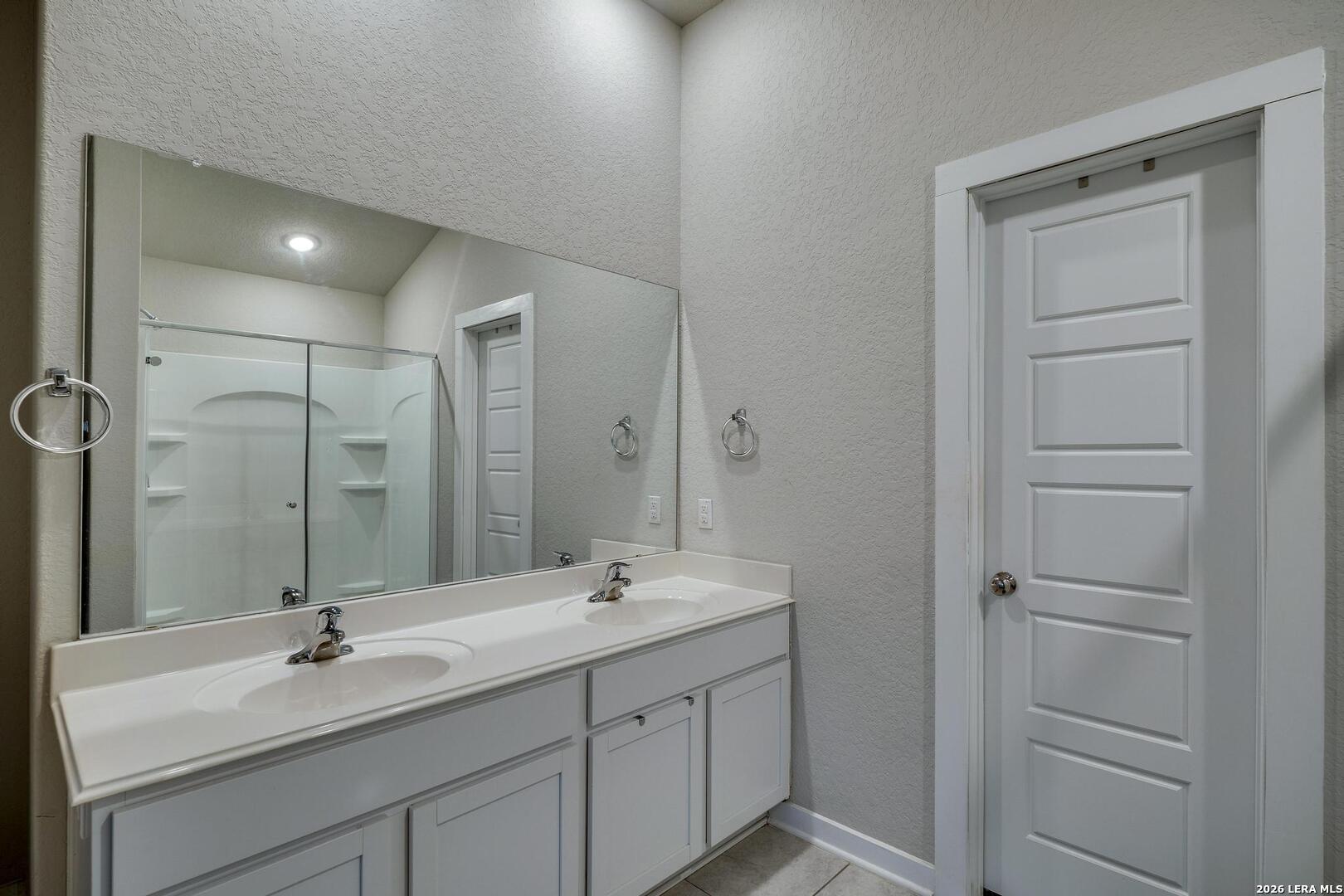 6910 Shiraz Way Converse, TX 78109 - Photo 14 of 25 a bathroom with a double vanity sink mirror and shower