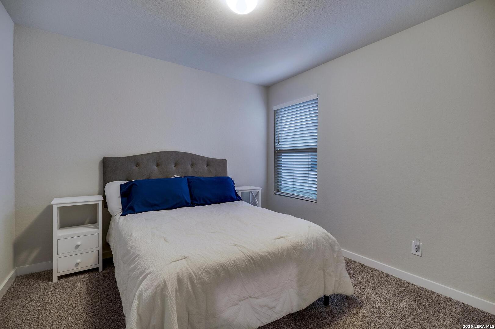 6910 Shiraz Way Converse, TX 78109 - Photo 18 of 25 a bedroom with a bed and a night stand
