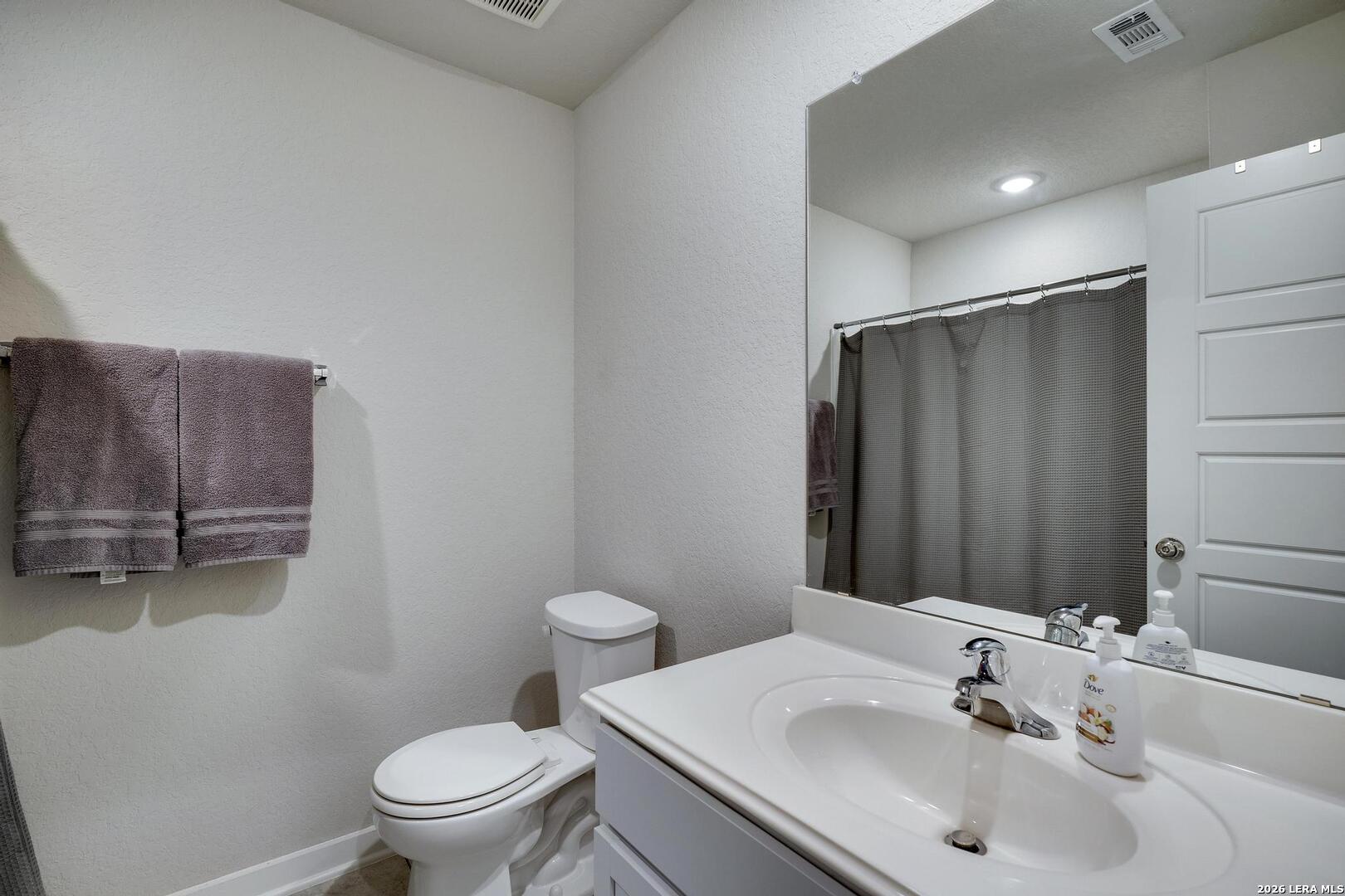 6910 Shiraz Way Converse, TX 78109 - Photo 21 of 25 a bathroom with a sink toilet and mirror
