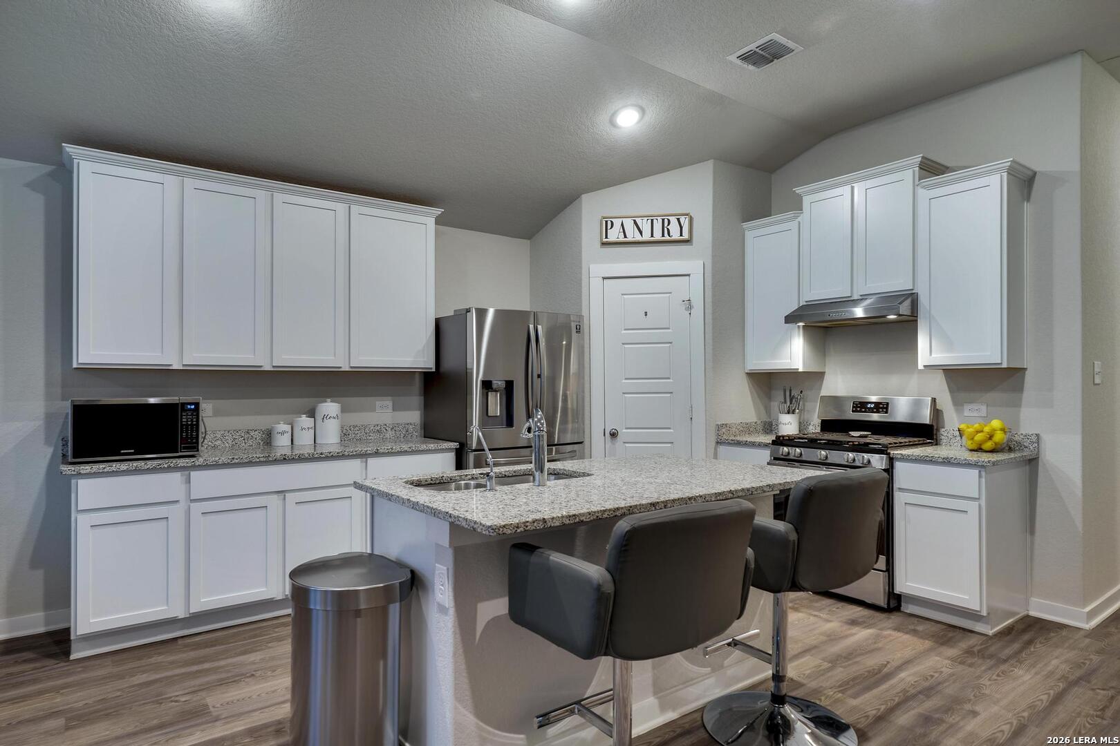 6910 Shiraz Way Converse, TX 78109 - Photo 6 of 25 a kitchen with a sink cabinets and wooden floor