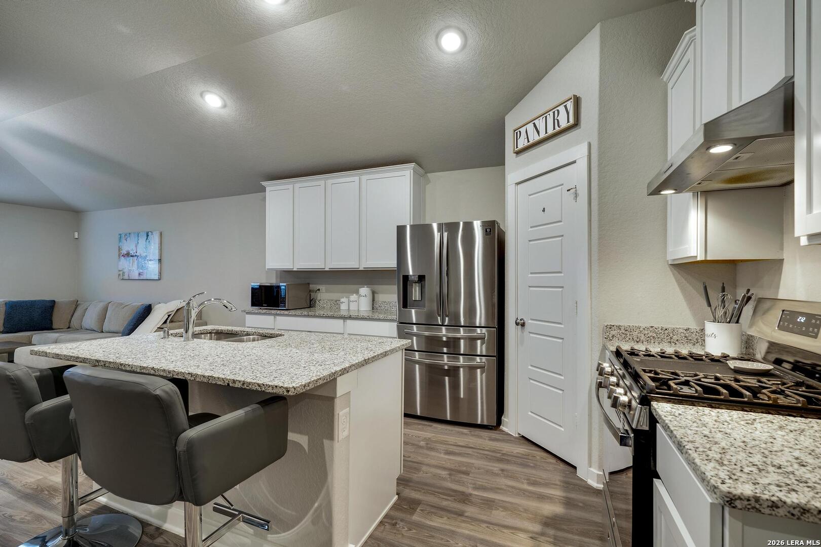6910 Shiraz Way Converse, TX 78109 - Photo 7 of 25 a kitchen with stainless steel appliances granite countertop a stove refrigerator sink and cabinets