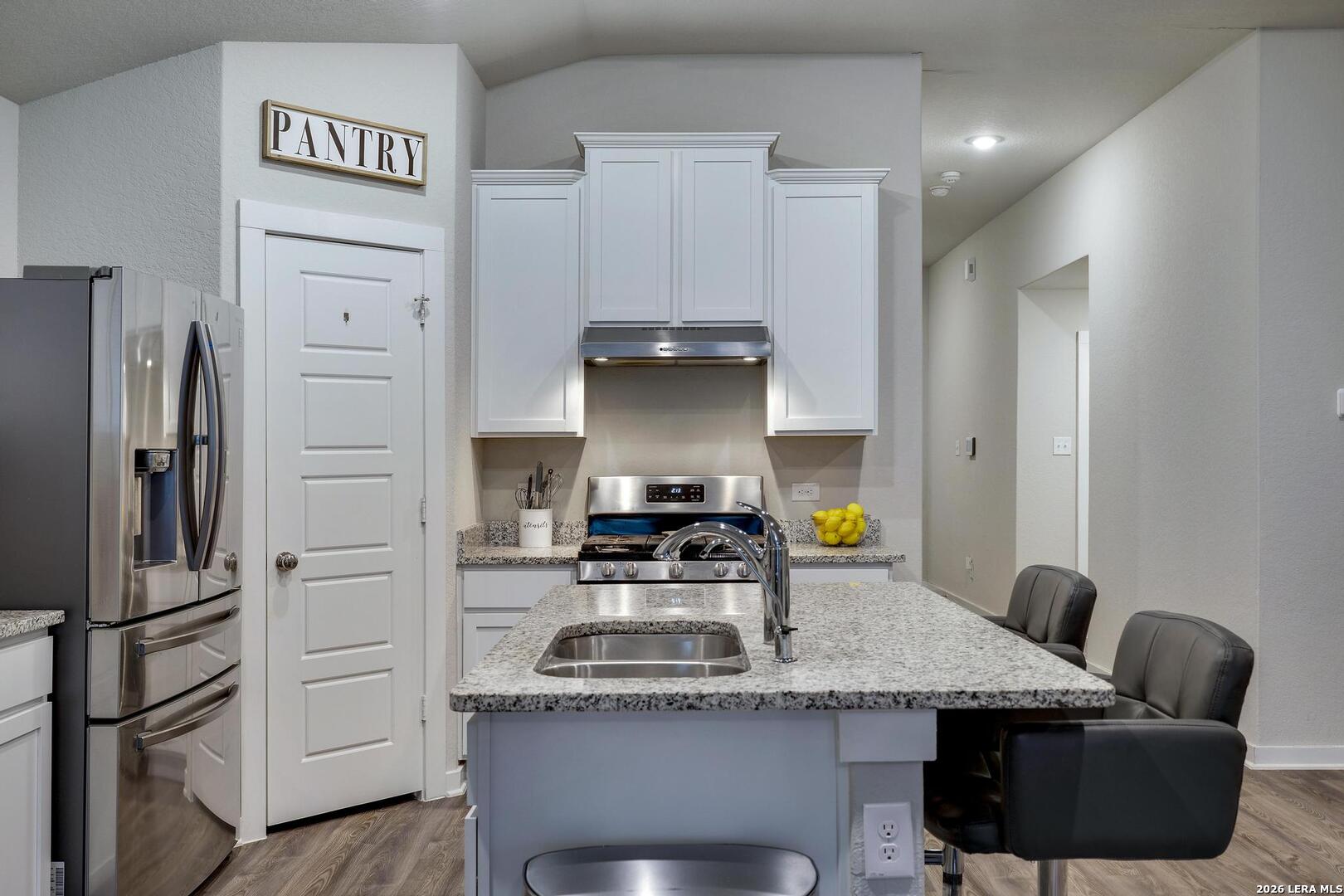 6910 Shiraz Way Converse, TX 78109 - Photo 8 of 25 a kitchen with stainless steel appliances granite countertop a stove a refrigerator and a refrigerator