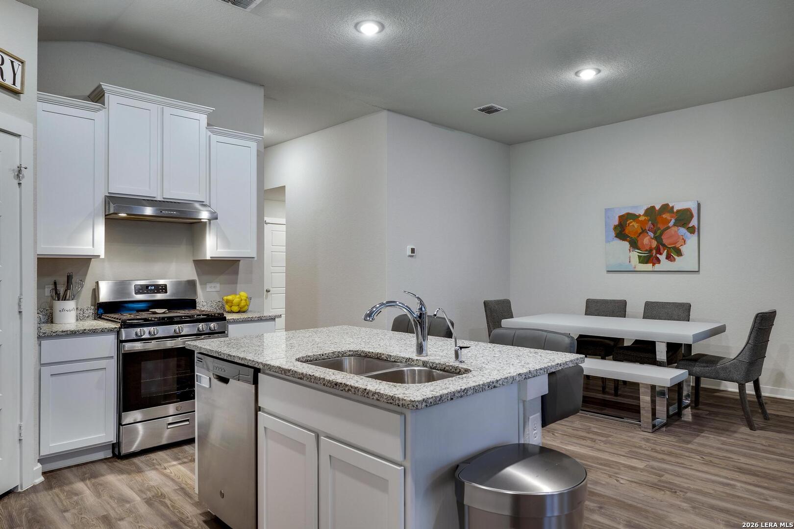 6910 Shiraz Way Converse, TX 78109 - Photo 10 of 25 a kitchen with granite countertop a sink and a stove top oven
