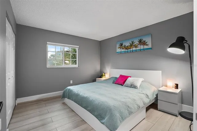 a bedroom with a bed and a painting on the wall