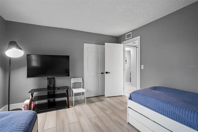 a bedroom with a bed and a flat screen tv