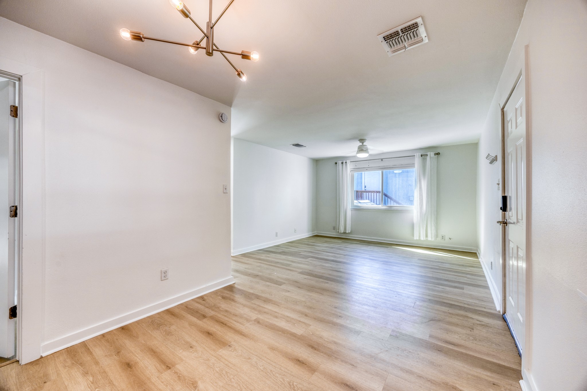Spare room with light wood-style floors and a chandelier