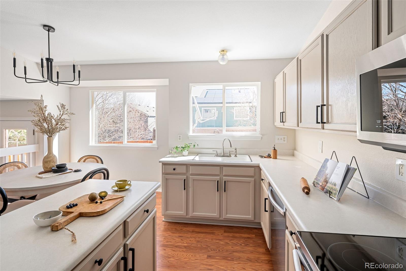 9741 Moss Rose Circle Highlands Ranch, CO 80129 - Photo 12 of 46 a kitchen that has a sink a stove and chairs in it