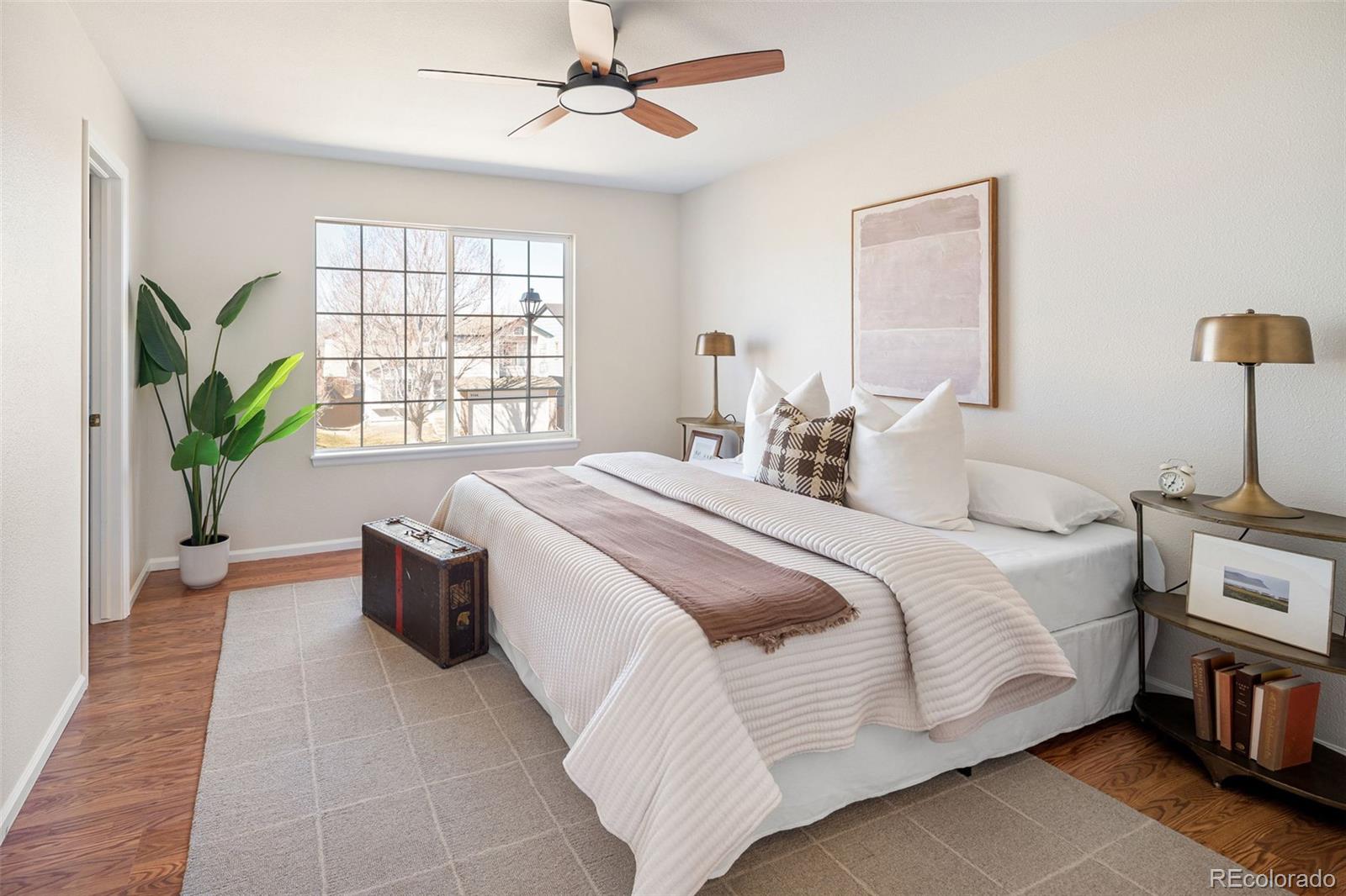 9741 Moss Rose Circle Highlands Ranch, CO 80129 - Photo 26 of 46 a bedroom with a large bed and a chandelier