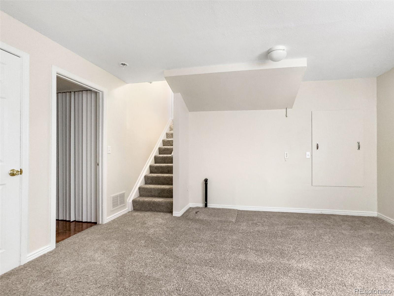9741 Moss Rose Circle Highlands Ranch, CO 80129 - Photo 38 of 46 a view of a hallway with staircase and white walls