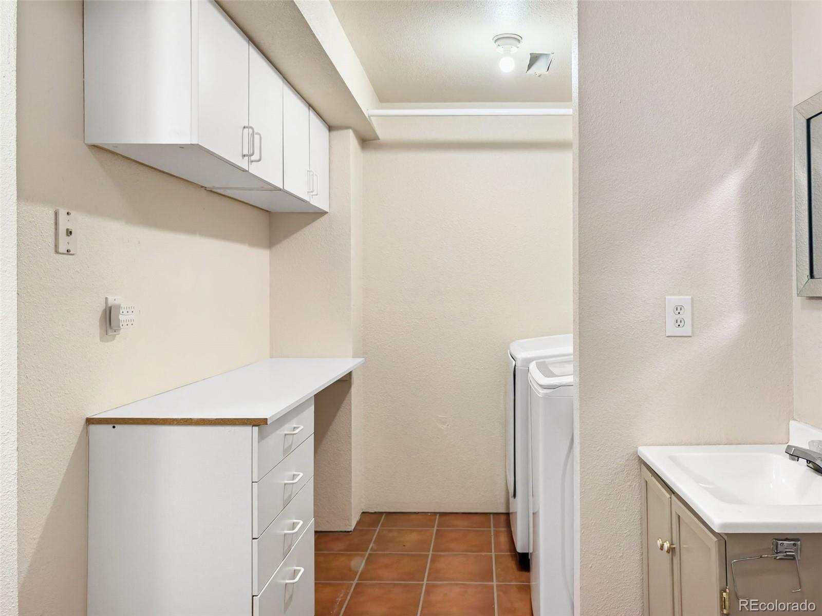 9741 Moss Rose Circle Highlands Ranch, CO 80129 - Photo 39 of 46 a kitchen with a sink a refrigerator and cabinets