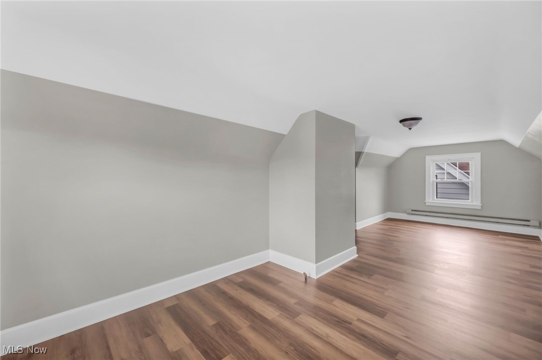 3528 Daleford Road Cleveland, OH 44120 - Photo 25 of 30 Additional living space featuring baseboard heating, lofted ceiling, wood finished floors, and baseboards
