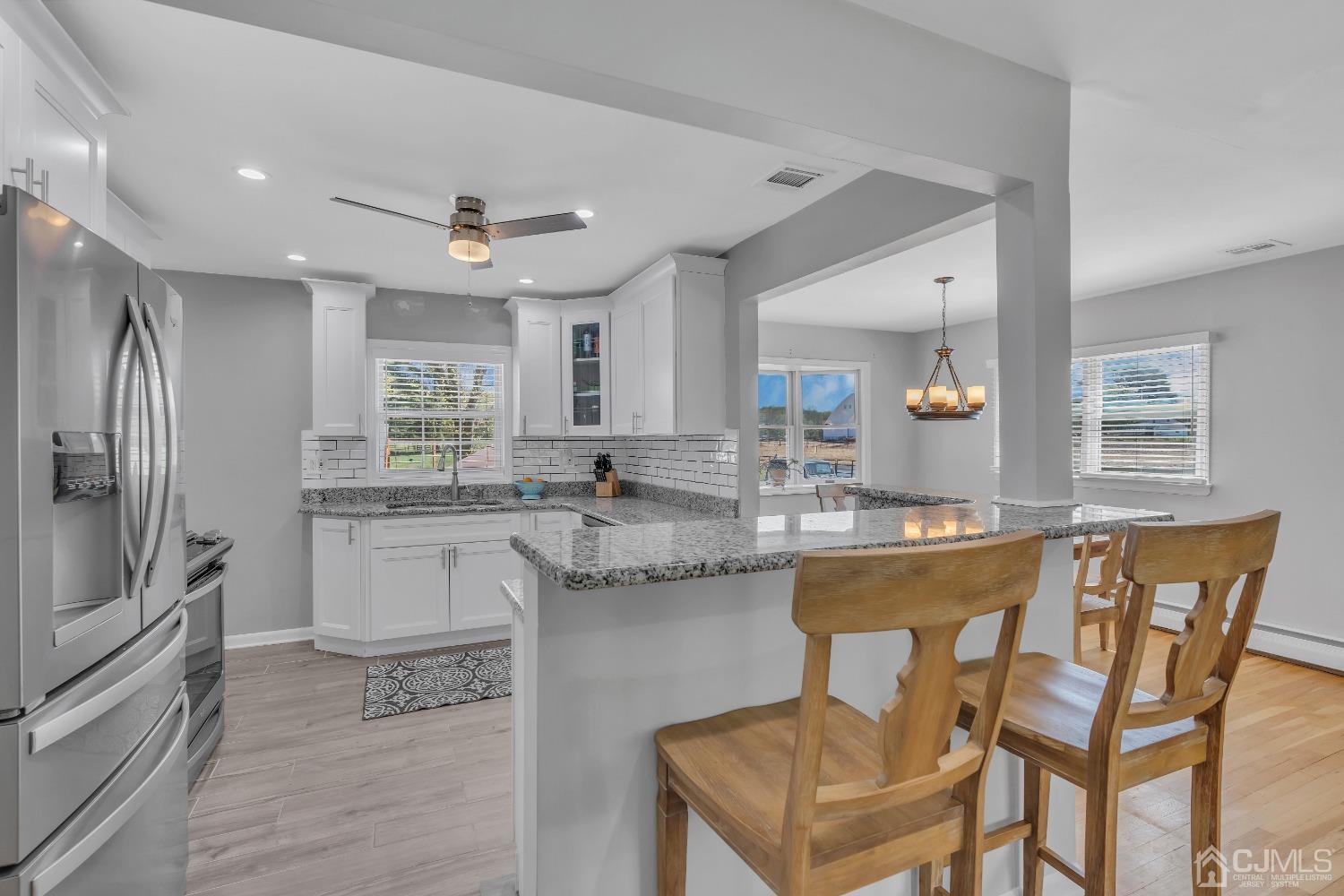 247 Davidson's Mill Road Monroe Township, NJ 08831 - Photo 11 of 55 a kitchen with stainless steel appliances granite countertop a kitchen island hardwood floor and a sink