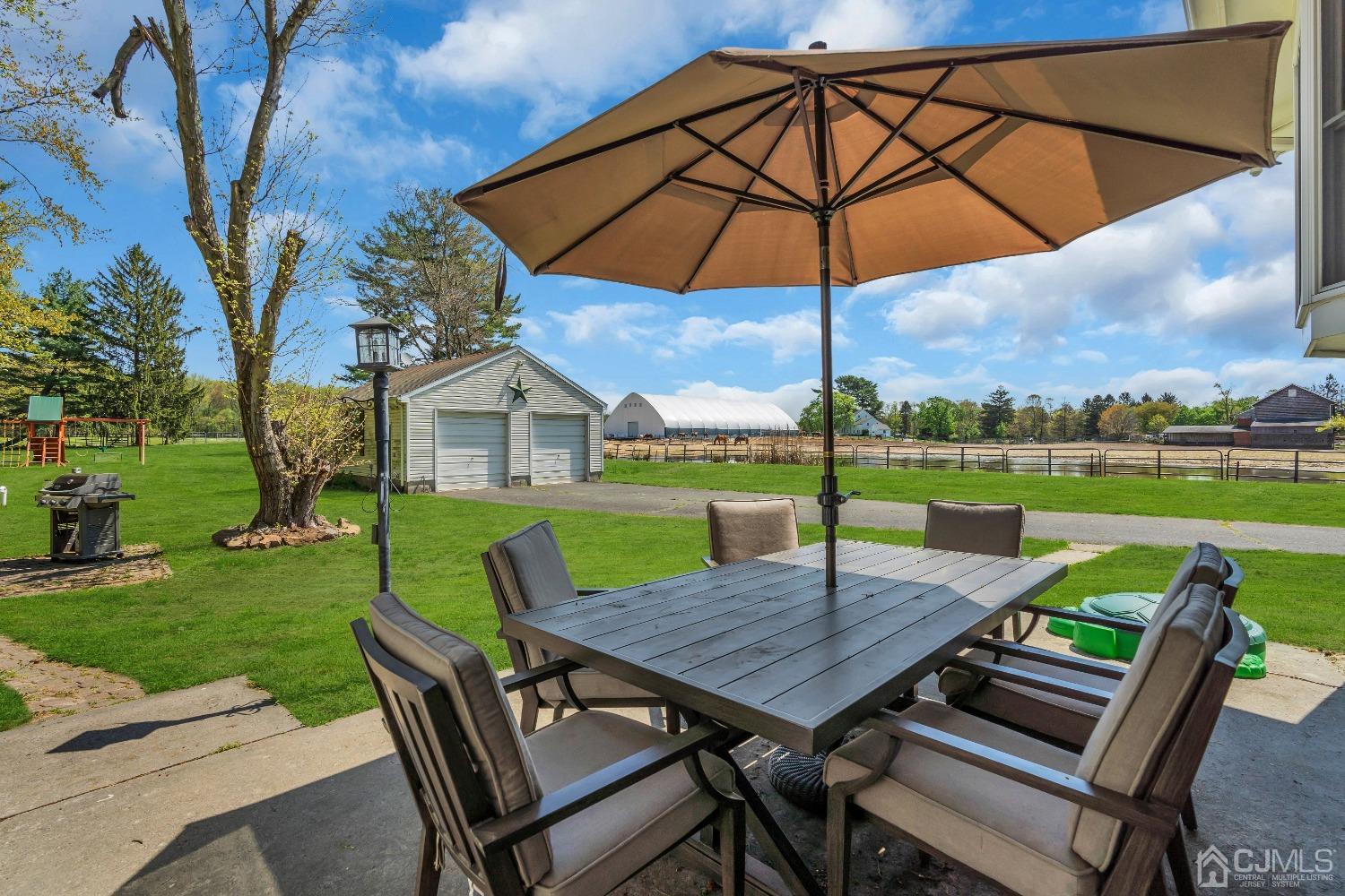 247 Davidson's Mill Road Monroe Township, NJ 08831 - Photo 36 of 55 a view of a roof deck with table and chairs under an umbrella