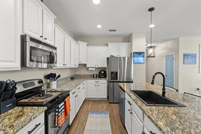 a kitchen with a sink stove top oven and refrigerator