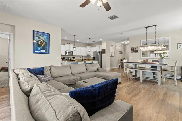 a living room with furniture kitchen view and a dining table