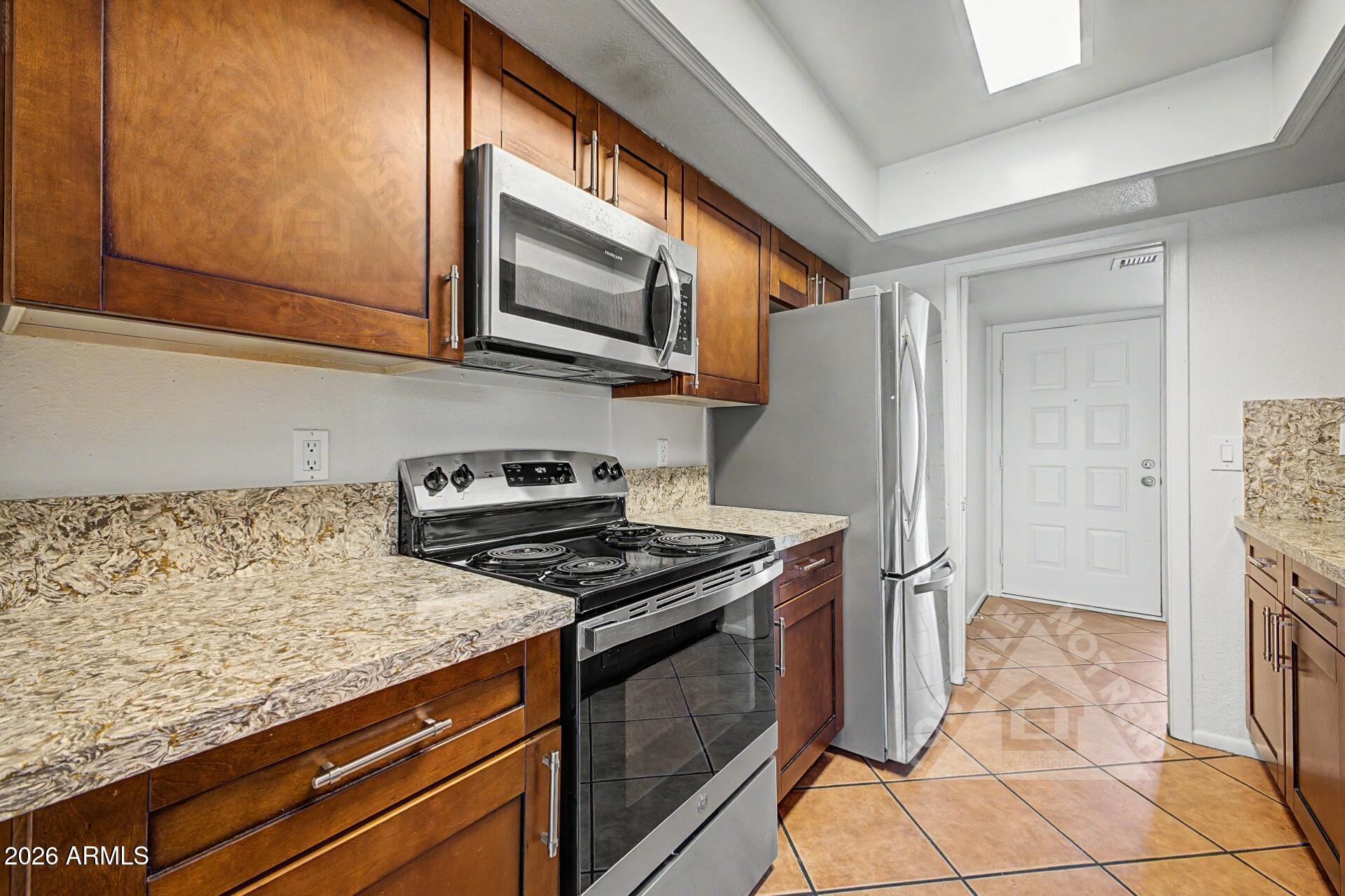 912 East Villa Rita Drive Phoenix, AZ 85022 - Photo 3 of 27 a kitchen with stainless steel appliances granite countertop a stove microwave and refrigerator