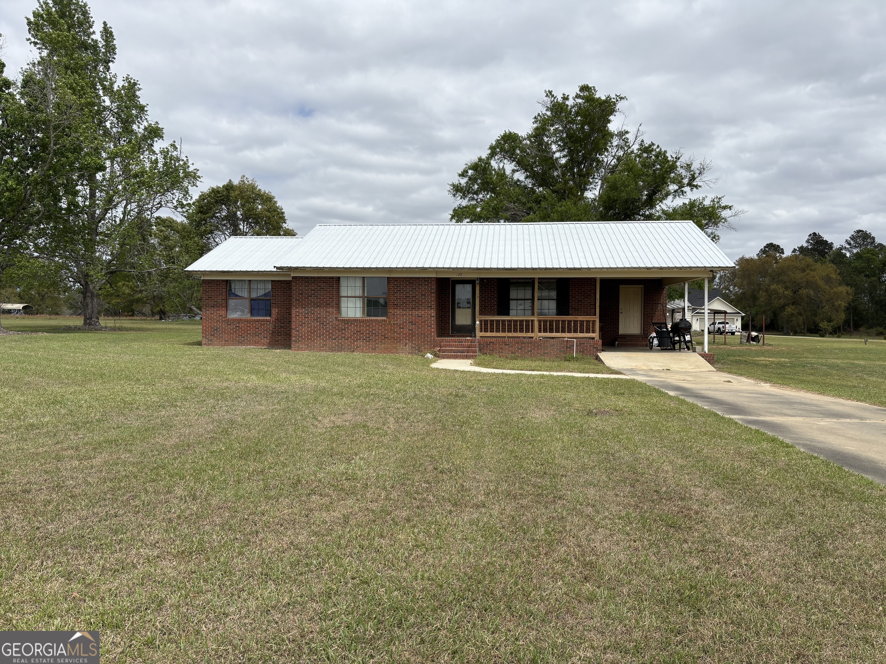 a view of a big house with a big yard and large trees