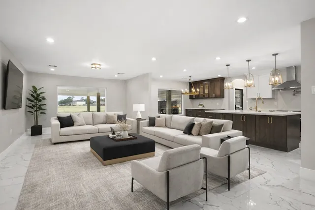 a kitchen with kitchen island a stove a sink and white cabinets