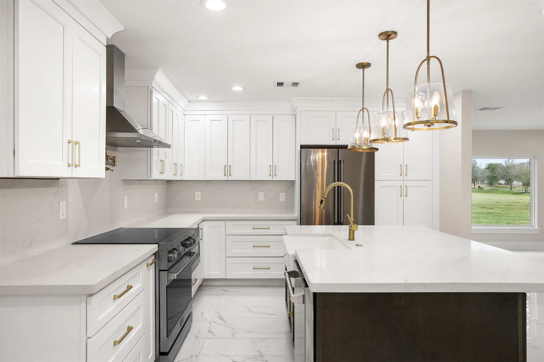4002 Dixie Farm Road Pearland, TX 77581 - Photo 9 of 29 a kitchen with kitchen island a stove a sink and white cabinets