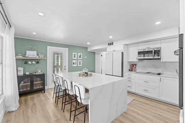 a kitchen with a table chairs refrigerator and cabinets