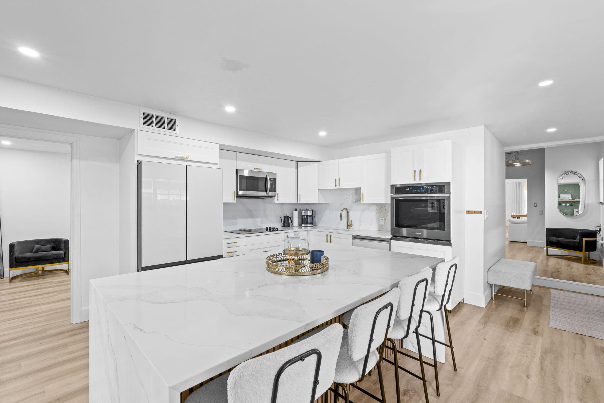 715 Kaye Street West Palm Beach, FL 33405 - Photo 18 of 40 a kitchen with stainless steel appliances granite countertop a stove a refrigerator a sink a dining table and chairs with wooden floor