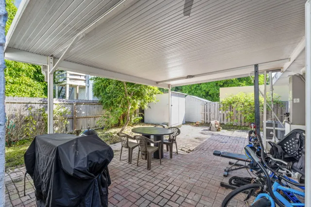 a view of a patio with table and chairs and floor to ceiling window
