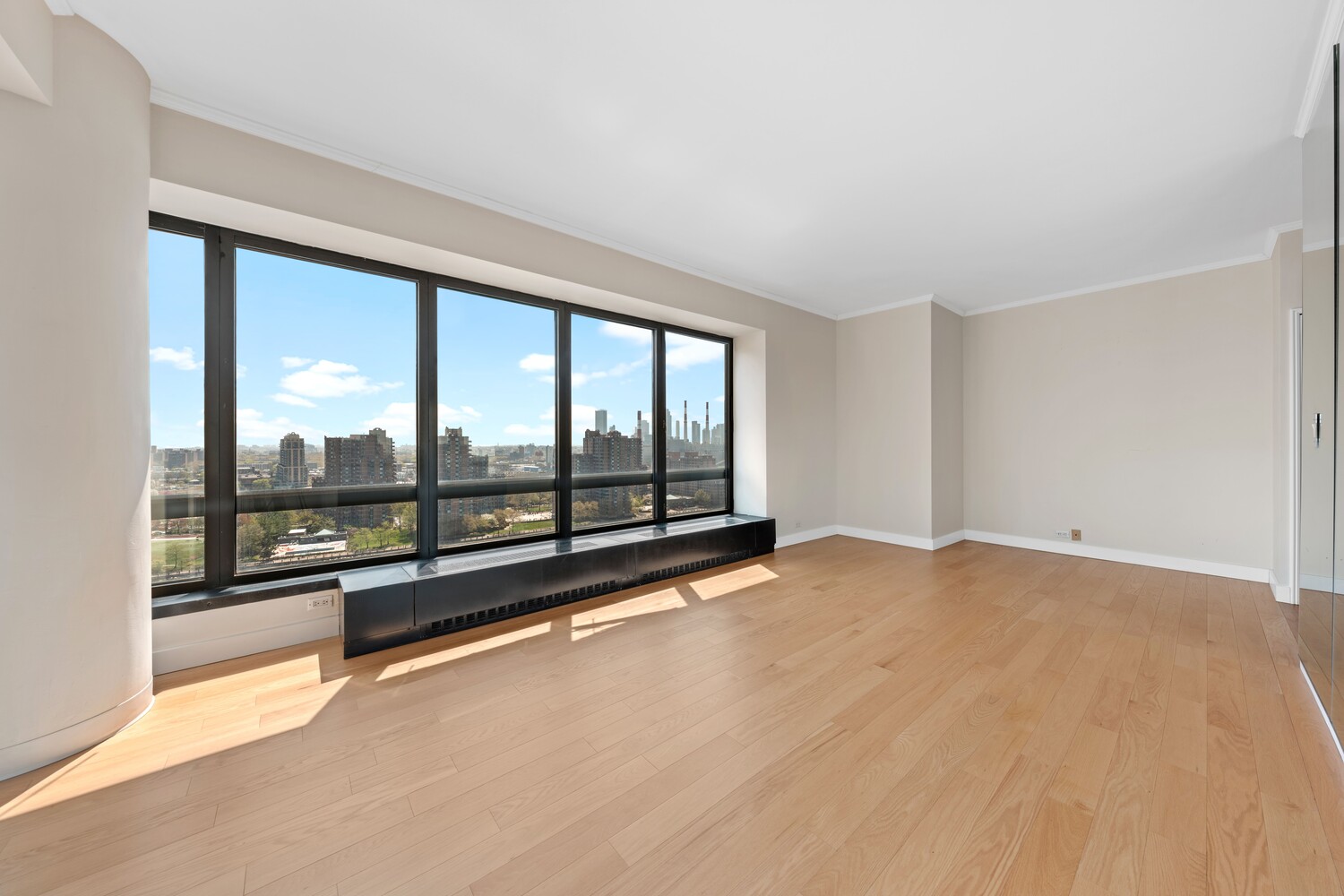 530 East 76th Street, Unit 18G Manhattan, NY 10021 - Photo 2 of 12 wooden floor in an empty room with a large window