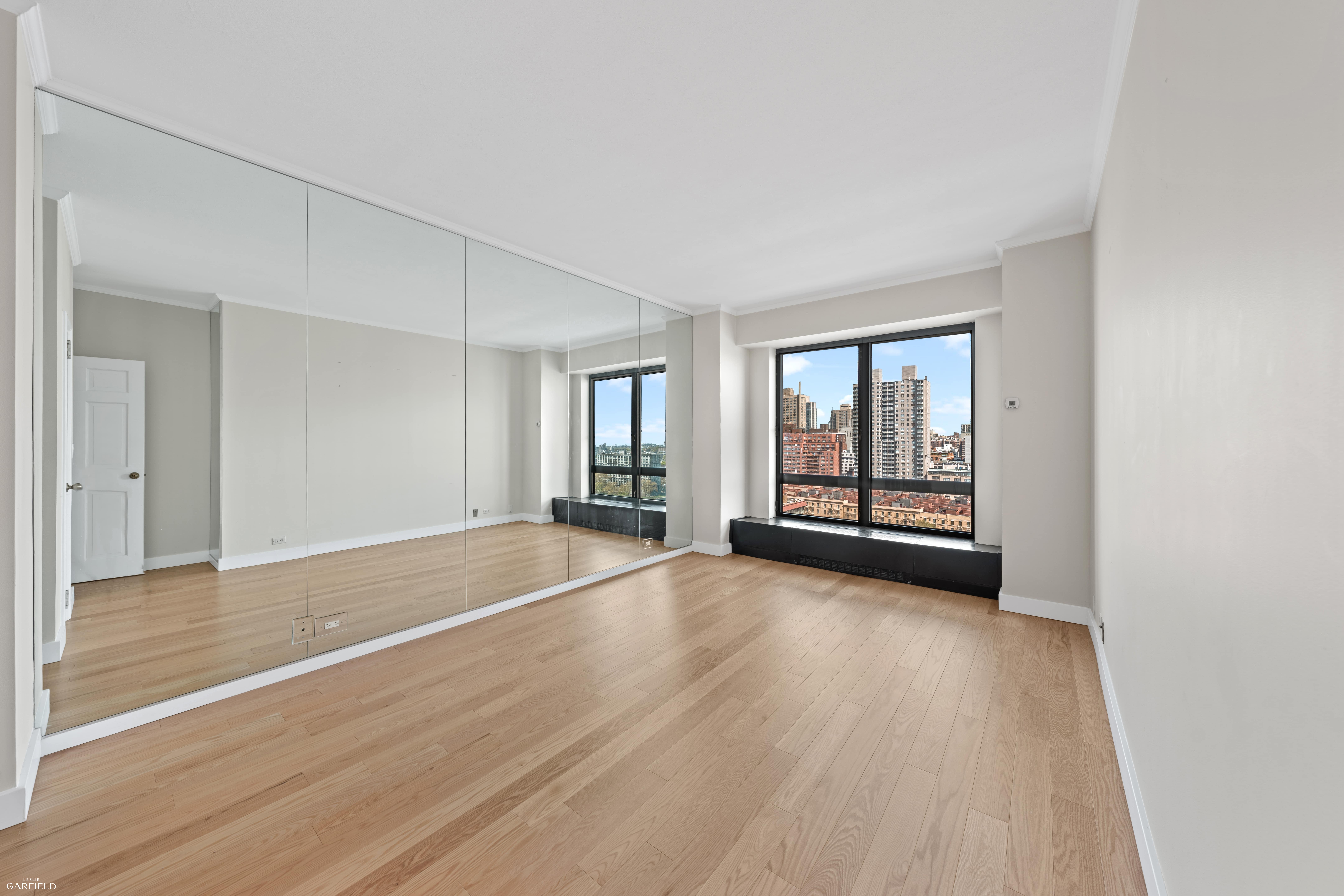530 East 76th Street, Unit 18G Manhattan, NY 10021 - Photo 5 of 16 a view of an empty room with wooden floor and a window