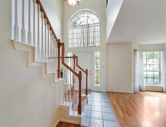 an entryway with wooden floor and stairs