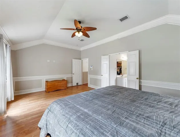 a bedroom with a large bed and a chandelier