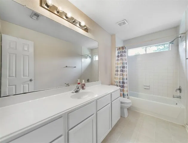 a bathroom with a double vanity sink mirror and bathtub