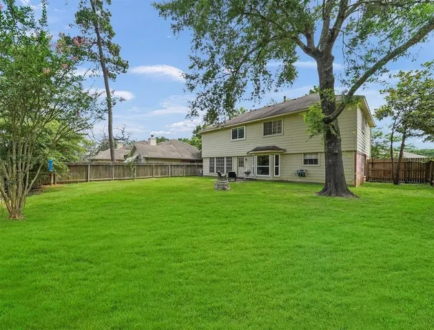 a view of a house with a big yard and large trees
