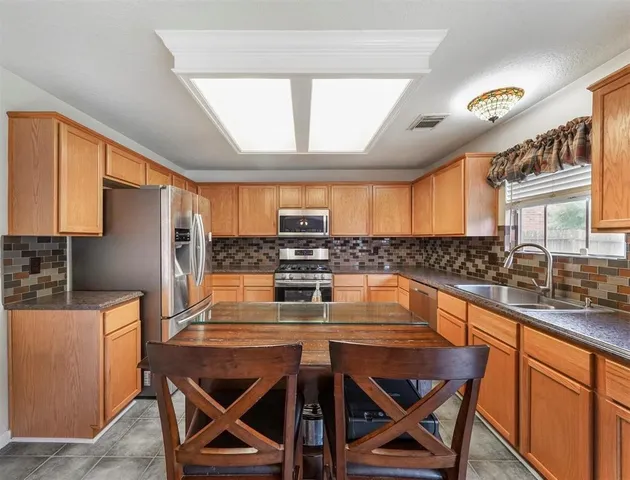 a kitchen with a table chairs sink and cabinets