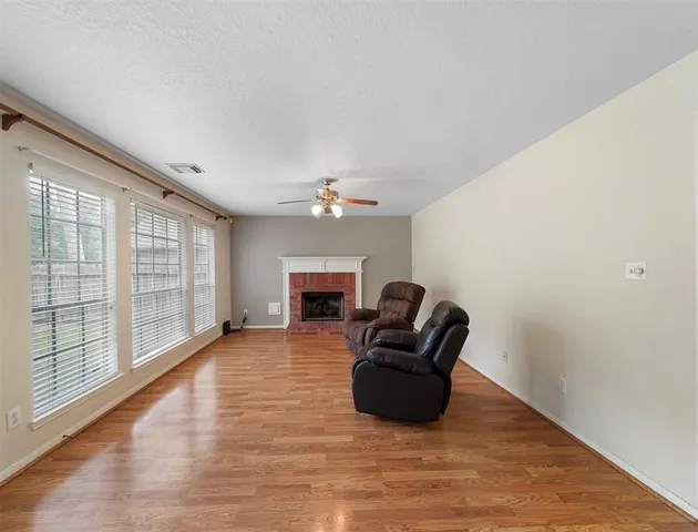 a living room with furniture a fireplace and a large window