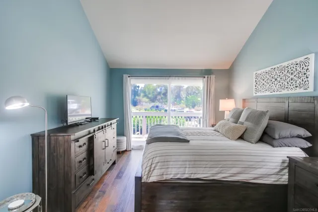 a bedroom with a large bed and a flat tv screen on a dresser