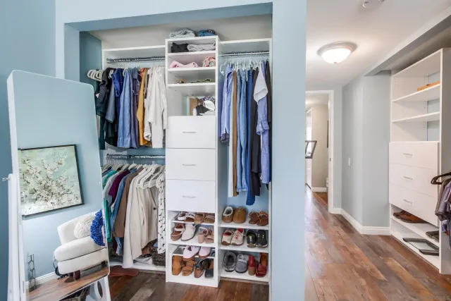 a view of walk in closet with clothes and shoes