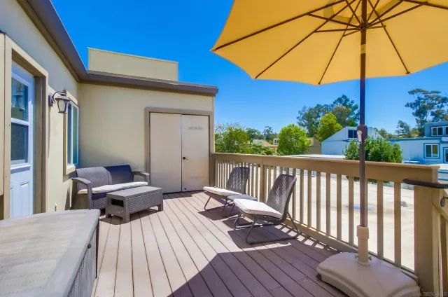 a view of a patio with a table and chairs under an umbrella