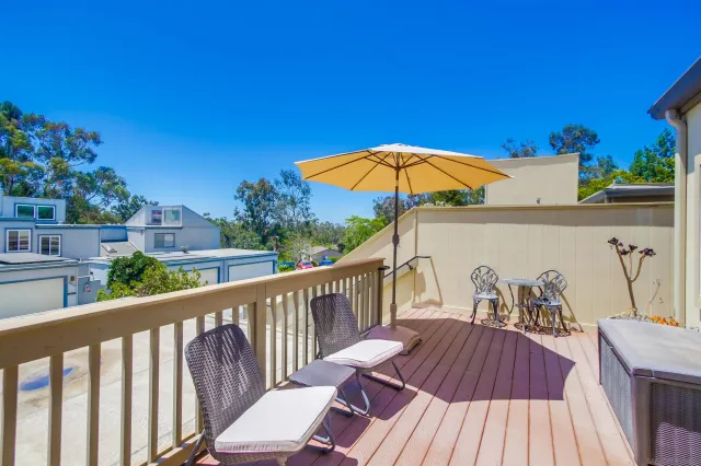 a view of a balcony with wooden floor and outdoor seating