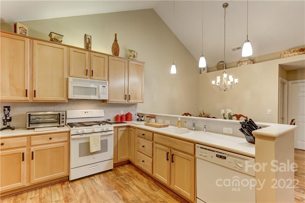728 Ledgestone Court Tega Cay, SC 29708 - Photo 6 of 30 a kitchen with a sink dishwasher and white cabinets with wooden floor