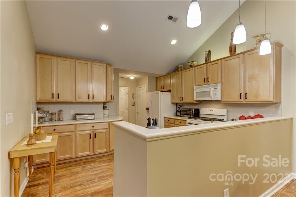 728 Ledgestone Court Tega Cay, SC 29708 - Photo 9 of 30 a room with kitchen island a sink a stove and cabinets