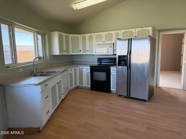 a kitchen with stainless steel appliances granite countertop a refrigerator a sink and a stove