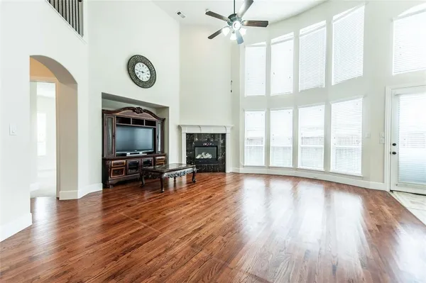 a view of a livingroom with furniture a fireplace wooden floor and a window