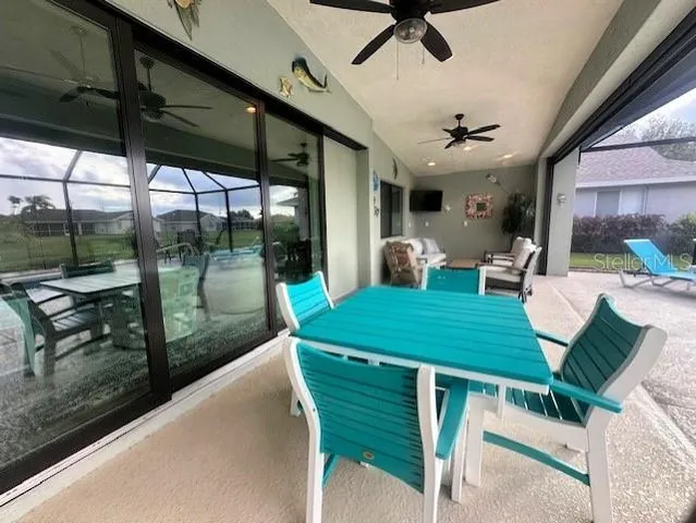 a view of a patio with a table chairs and a floor to ceiling window
