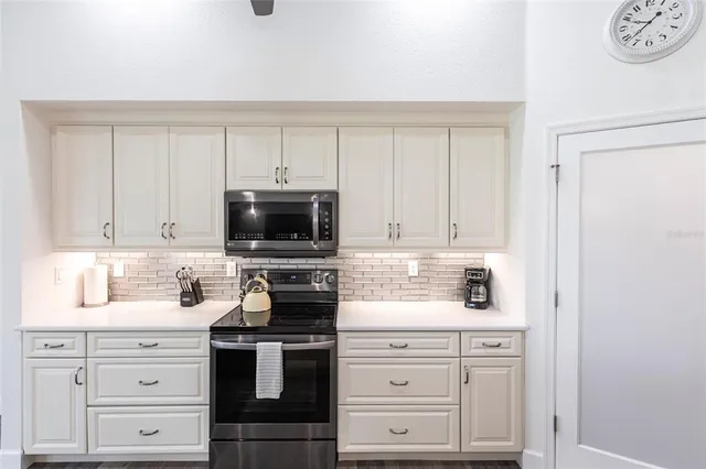 a kitchen with white cabinets and stainless steel appliances