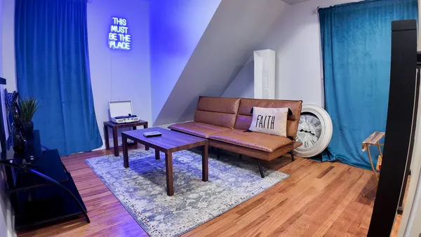 a living room with furniture a rug and a wall painting