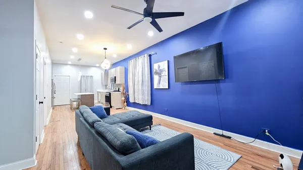 a living room with furniture and a ceiling fan