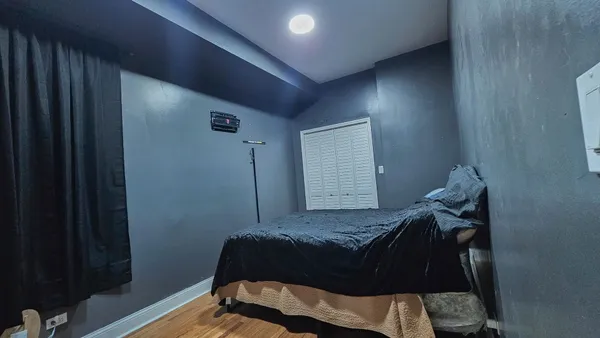 a bedroom with a bed and wooden floor