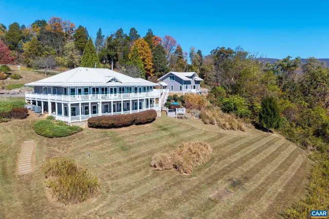 a view of a house with a yard and covered with trees